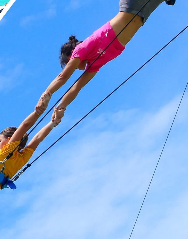 Flyer caught mid-air on a flying trapeze rig — Maldives resort — MACA flying trapeze rig
